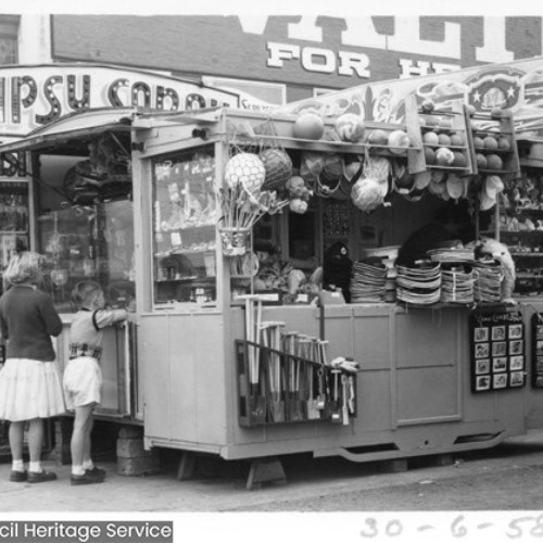 Two children looking at items for sale on a gifts stall.