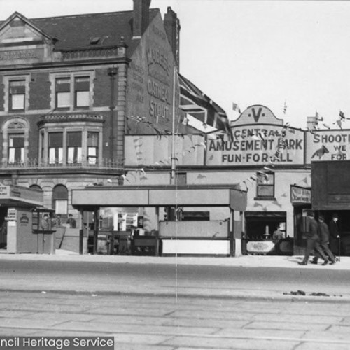 Exterior of the New Inn and Central Hotel on the left and the Central Amusement Park which advertises a Shooting Range and Fun For All on the right.