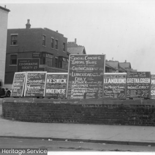 Large advertising boards for coach trips on the street corner.