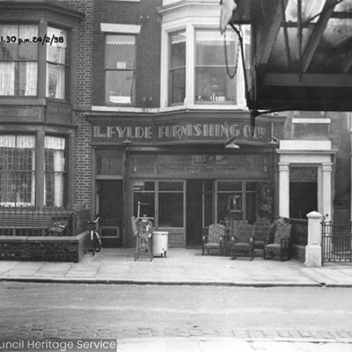 Shop front for The Fylde Furnishing Co. Ltd with a number of armchairs and other items on the forecourt.