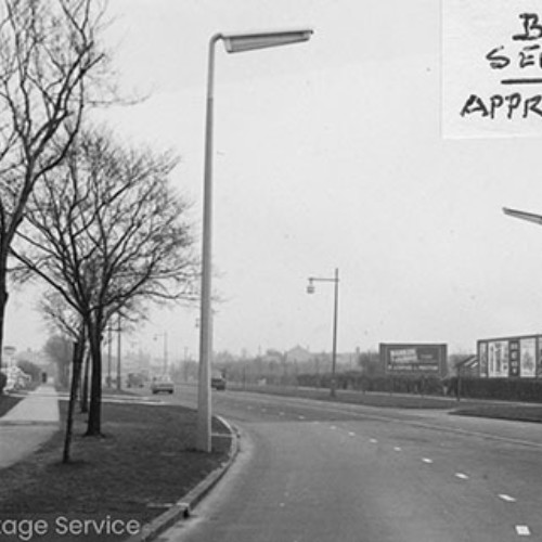 Road lined by street lights, with a sticker on the photograph reading Blackpool Service Station Approach From West.