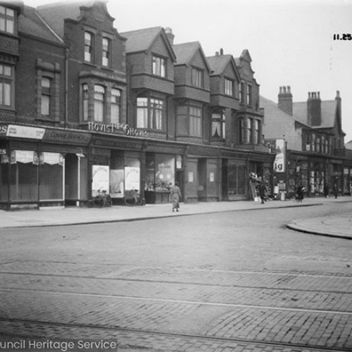 Shop fronts, including Taylors on the corner.