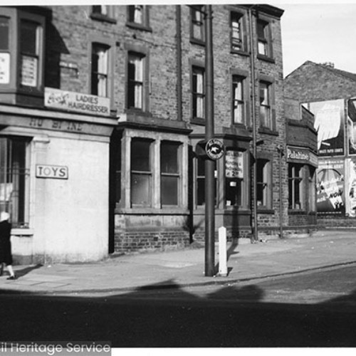 Street corner with signs for Toys and also a Ladies Hairdresser.