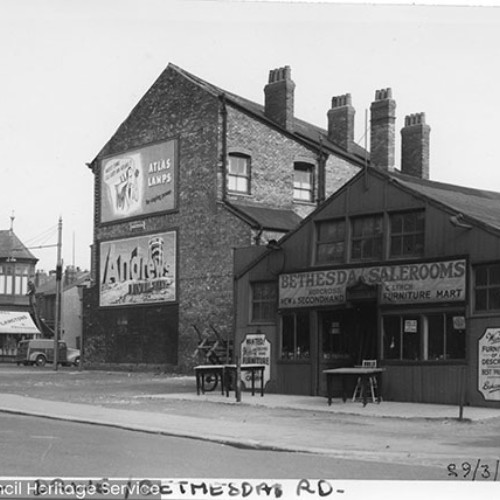 Street corner, with Bethesda Salerooms on the right with furniture on their forecourt.