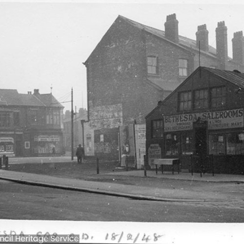 Street corner, with Bethesda Salerooms on the right with furniture on their forecourt.
