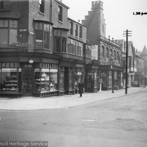 Street corner, with a number of shop fronts including Bamber and Co on the corner.