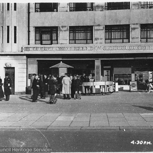 Group of people waiting by one of the doorways of a building.