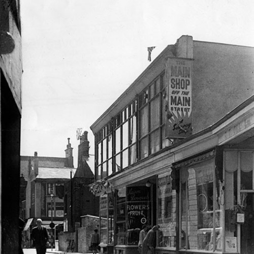 Shop front, advertised as The Main Shop Off The Main Street, flowers and fruit.