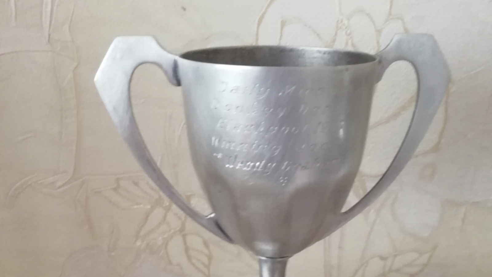 A silver trophy on a black base.