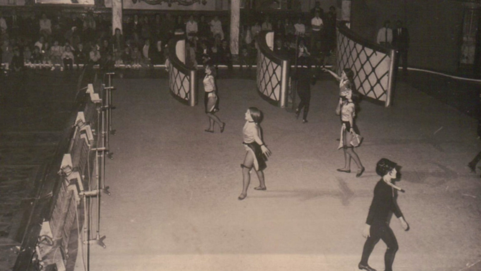 A group of dancers performing on a stage, wearing Parisian inspired costumes.