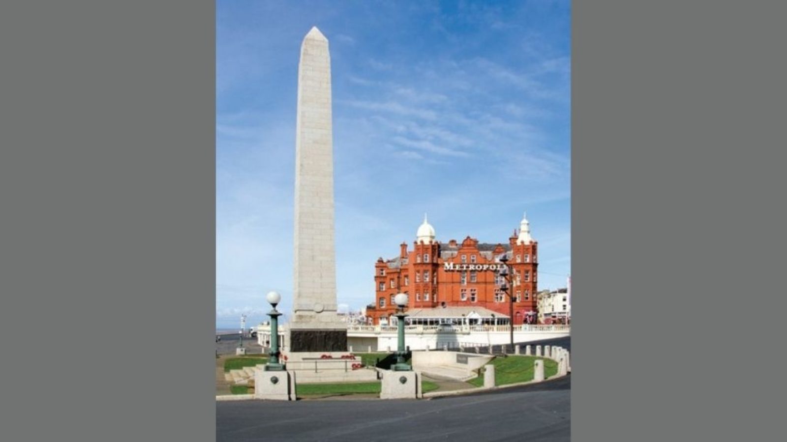 A cenotaph in the foreground and large hotel building in the background.