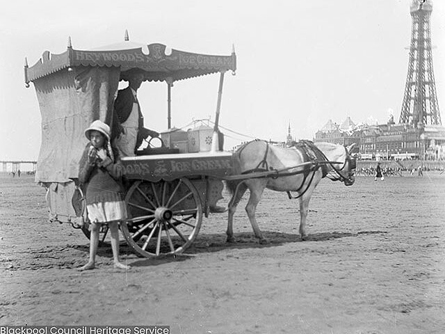 An old photo of a girl  on the beach beside an horse lead ice cream cart