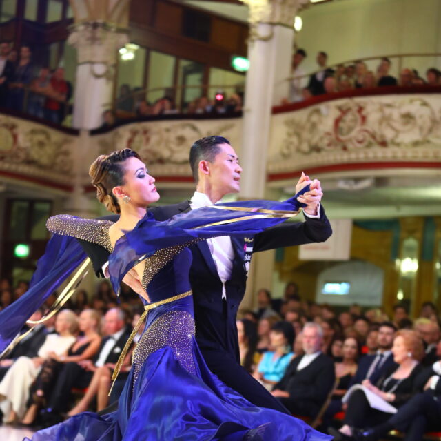 Ballroom dancers performing in front of a crowd