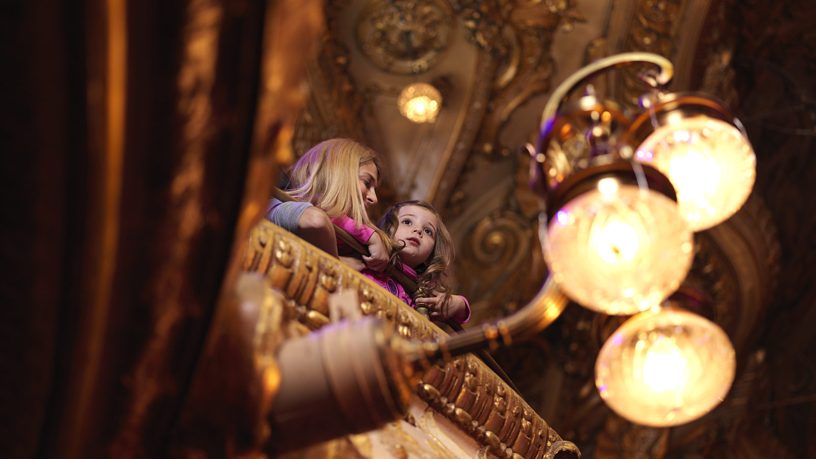 A photograph of a lady and little girl sat in the circle of the theatre.