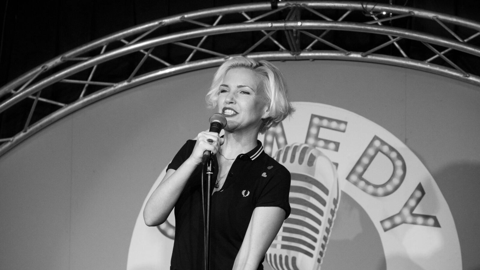 Black & white image of Ruth Cockburn performing at the Comedy Station Comedy Club, Blackpool.