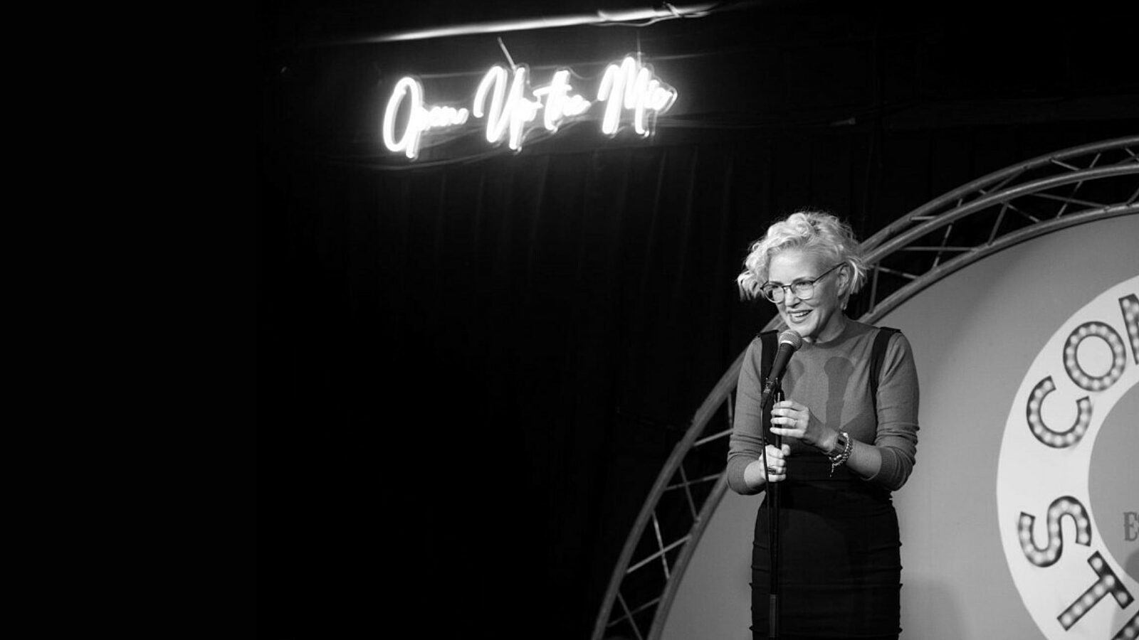 Black & white image of Ruth Cockburn performing at the Comedy Station Comedy Club, Blackpool.