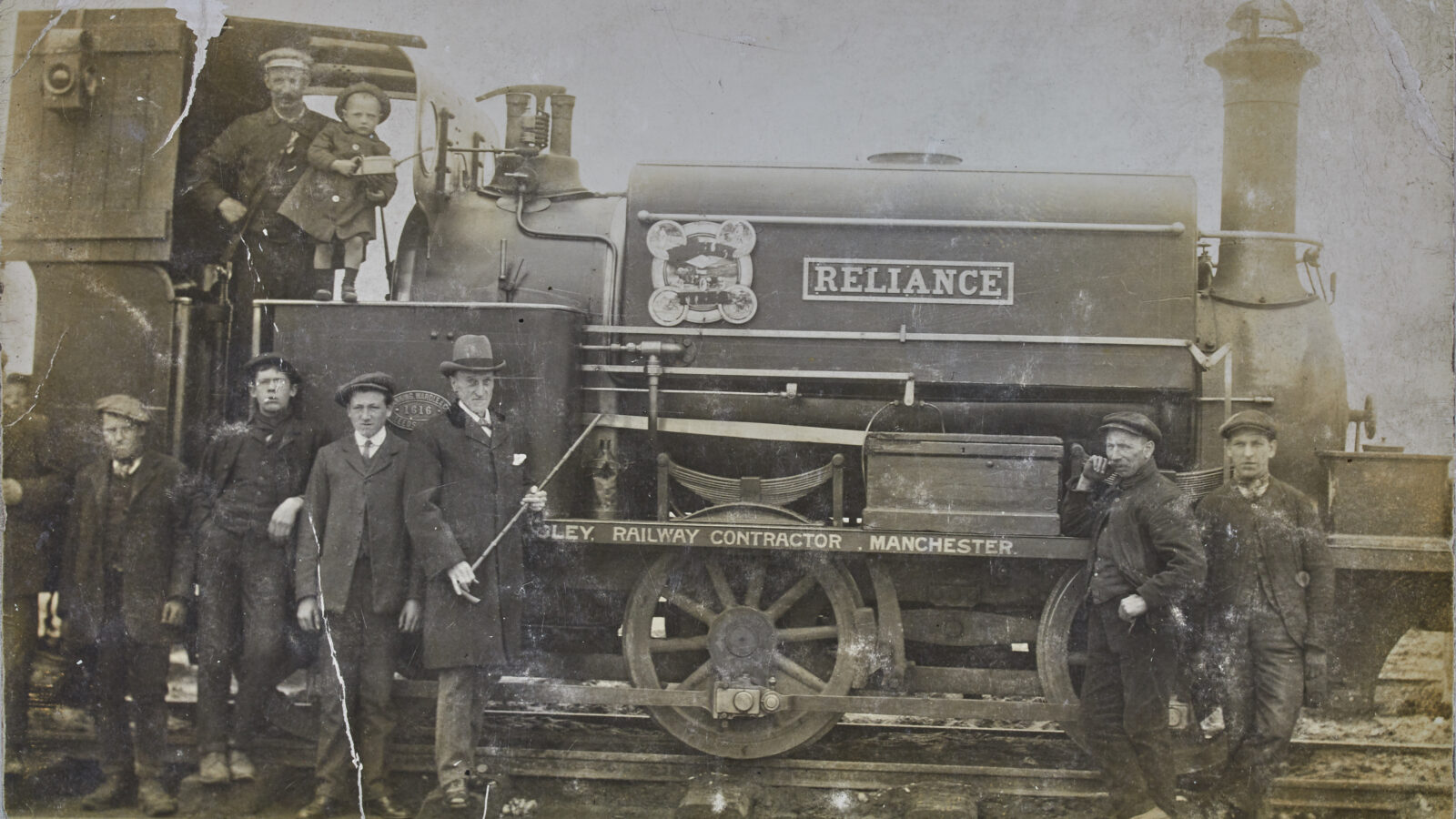 Black and white photograph of a steam engine and workers.