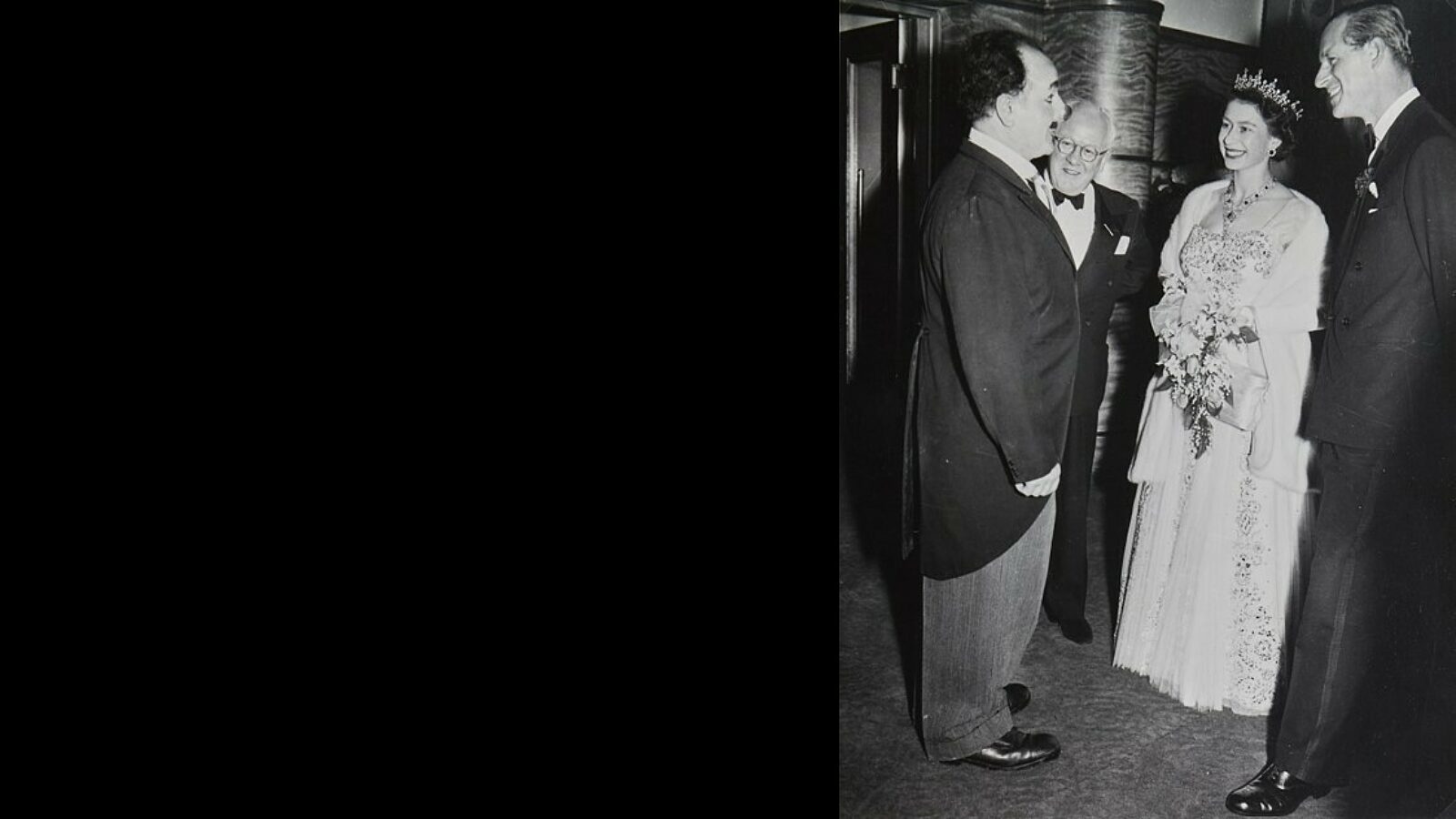 Black and white picture of The Queen and the Duke of Edinburgh meeting clown, Charlie Cairoli at Blackpool Opera House in 1955.