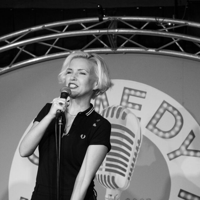 Black & White image of Ruth Cockburn on stage at the Comedy Station, Comedy Club.