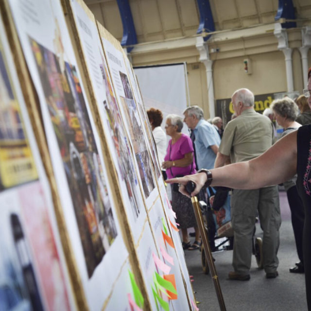 Couple looking and pointing at a display of images.