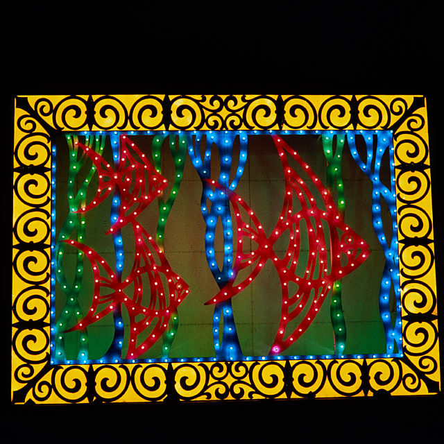 Illuminations tableau featuring 3 red fish surrounded by yellow pattern
