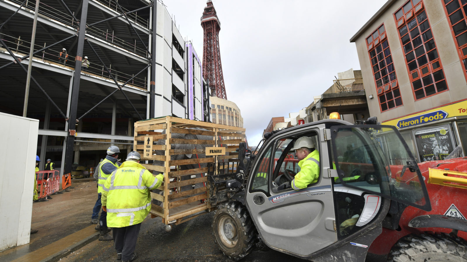 A crate containing a model elephant being lifted in front of the Showtown site
