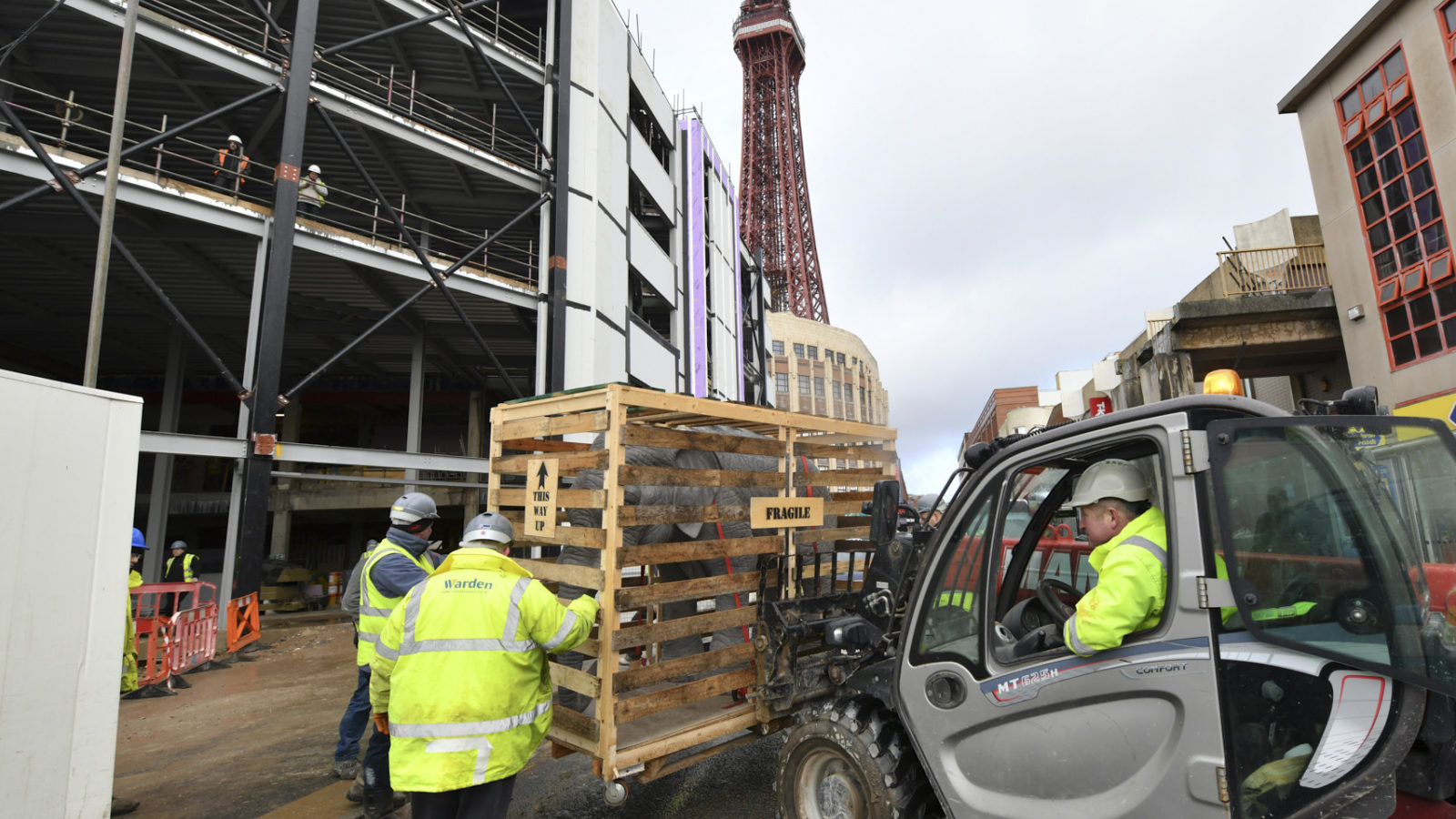 A crate containing a model elephant being lifted in front of the Showtown site