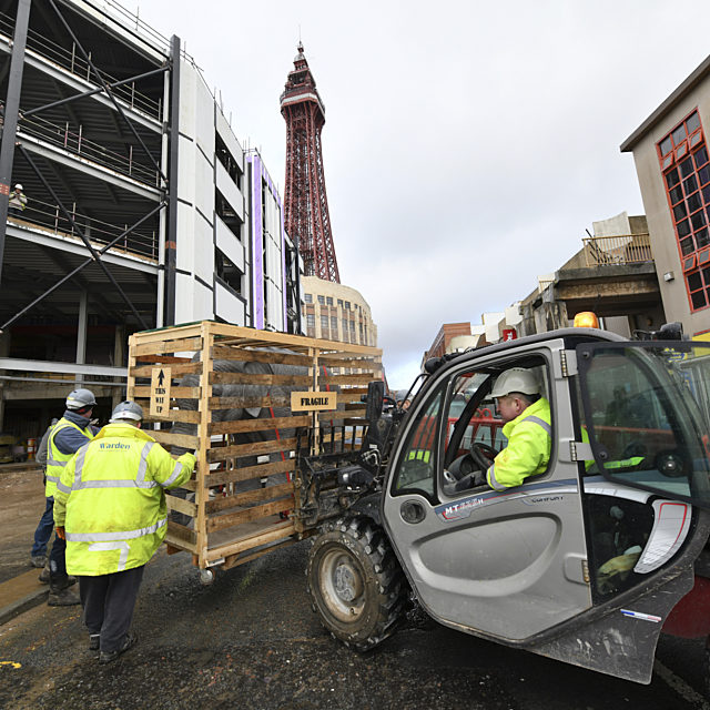 A crate containing a model elephant being lifted in front of the Showtown site