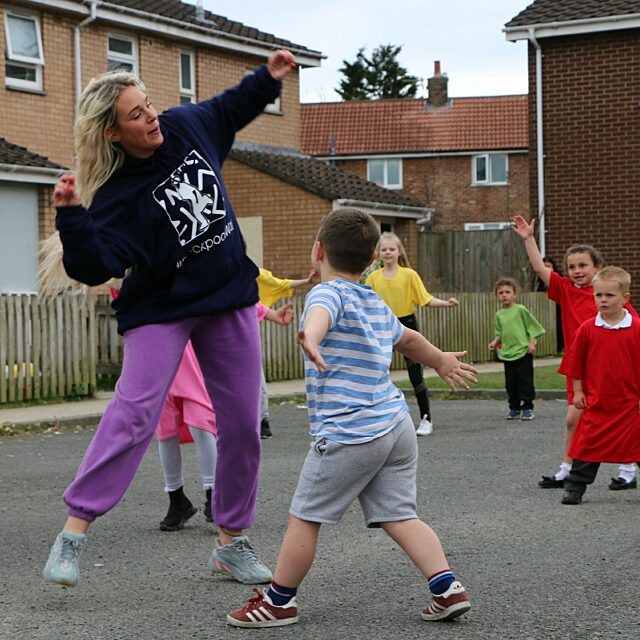 Image of House of Wingz dancing with residents during the doorstep dance workshop.