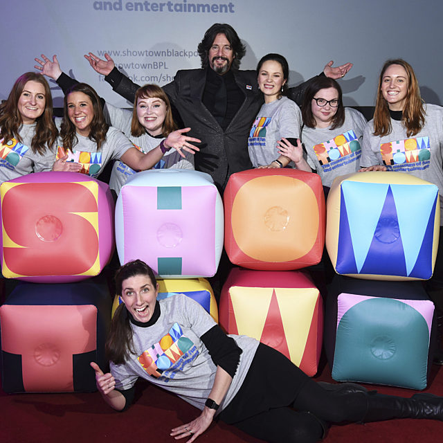 Showtown team and Laurence Lewellyn Bowen posing behind a large Showtown logo.