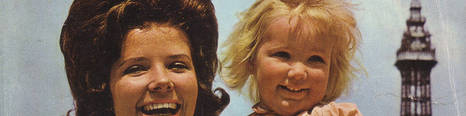 A 1960's lady stood with a smiling little girl in front of Blackpool Tower, with the word Blackpool above.