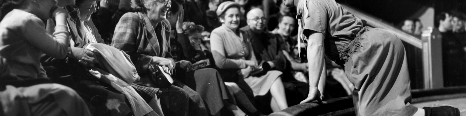 Black and white photograph of Clown, Charlie Cairoli leaning into the audience.