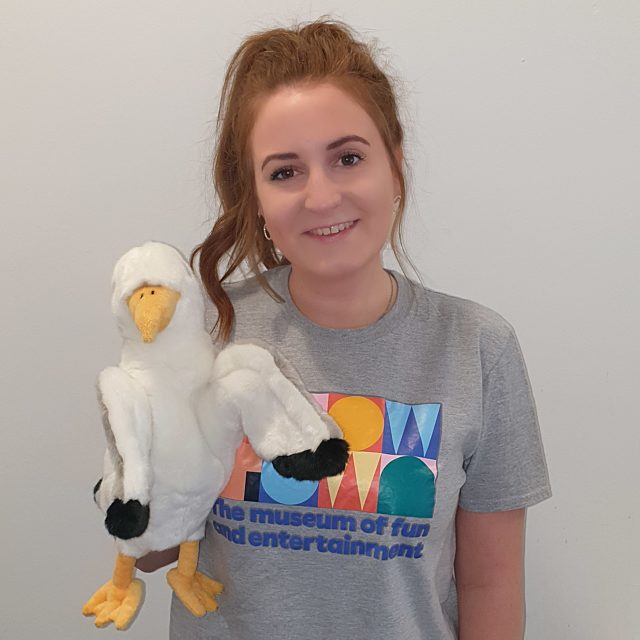 Kari Smiling in a Showtown t-shirt, holding a puppet seagull.
