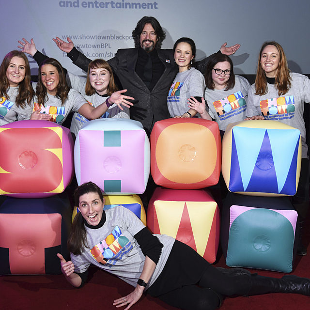 Showtown team and Lawrence Lewellyn Bowen stood behind an inflatable logo doing jazz hands.