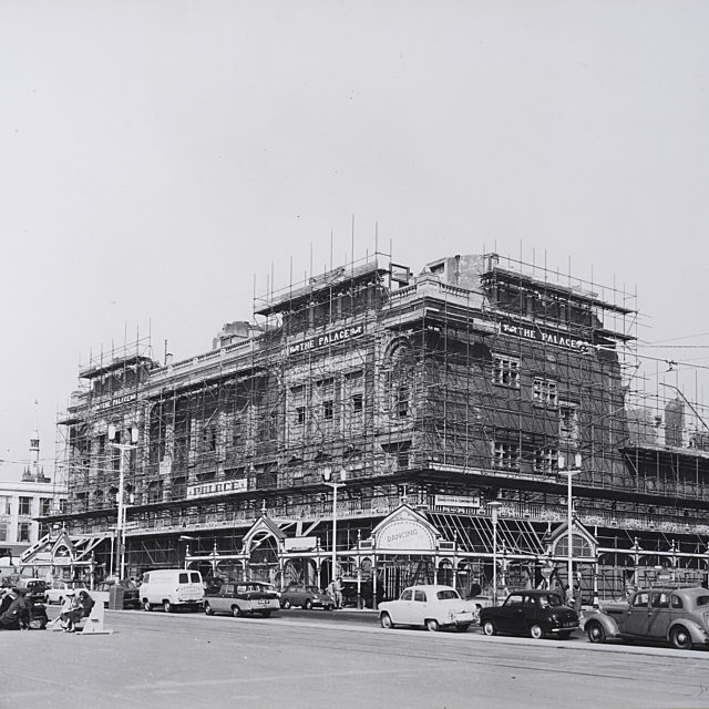 A old black and white photograph of a the Palace, covered in scaffolding