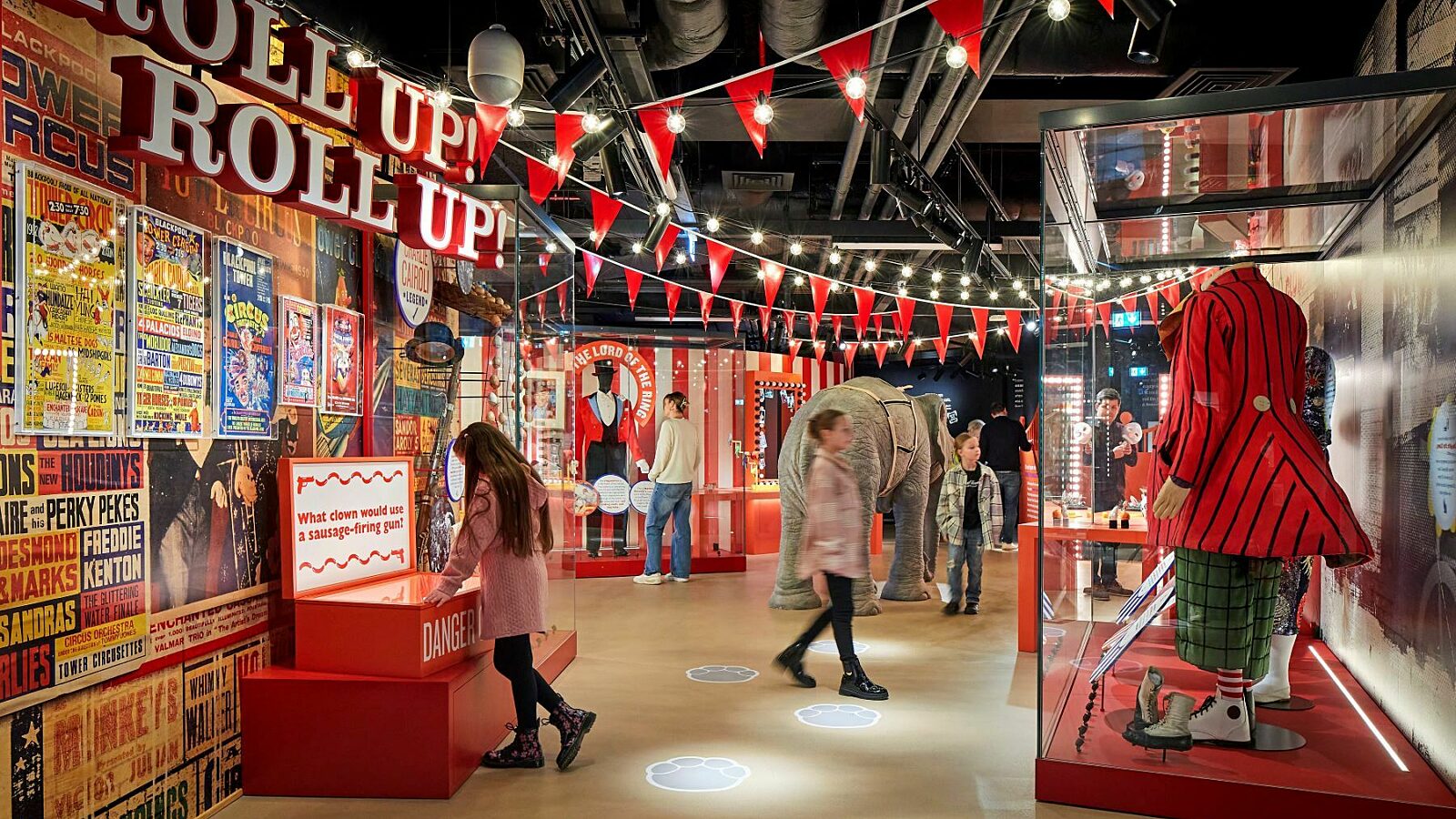 Image of Roll up gallery with family exploring circus related objects including clown and ring master costumes.