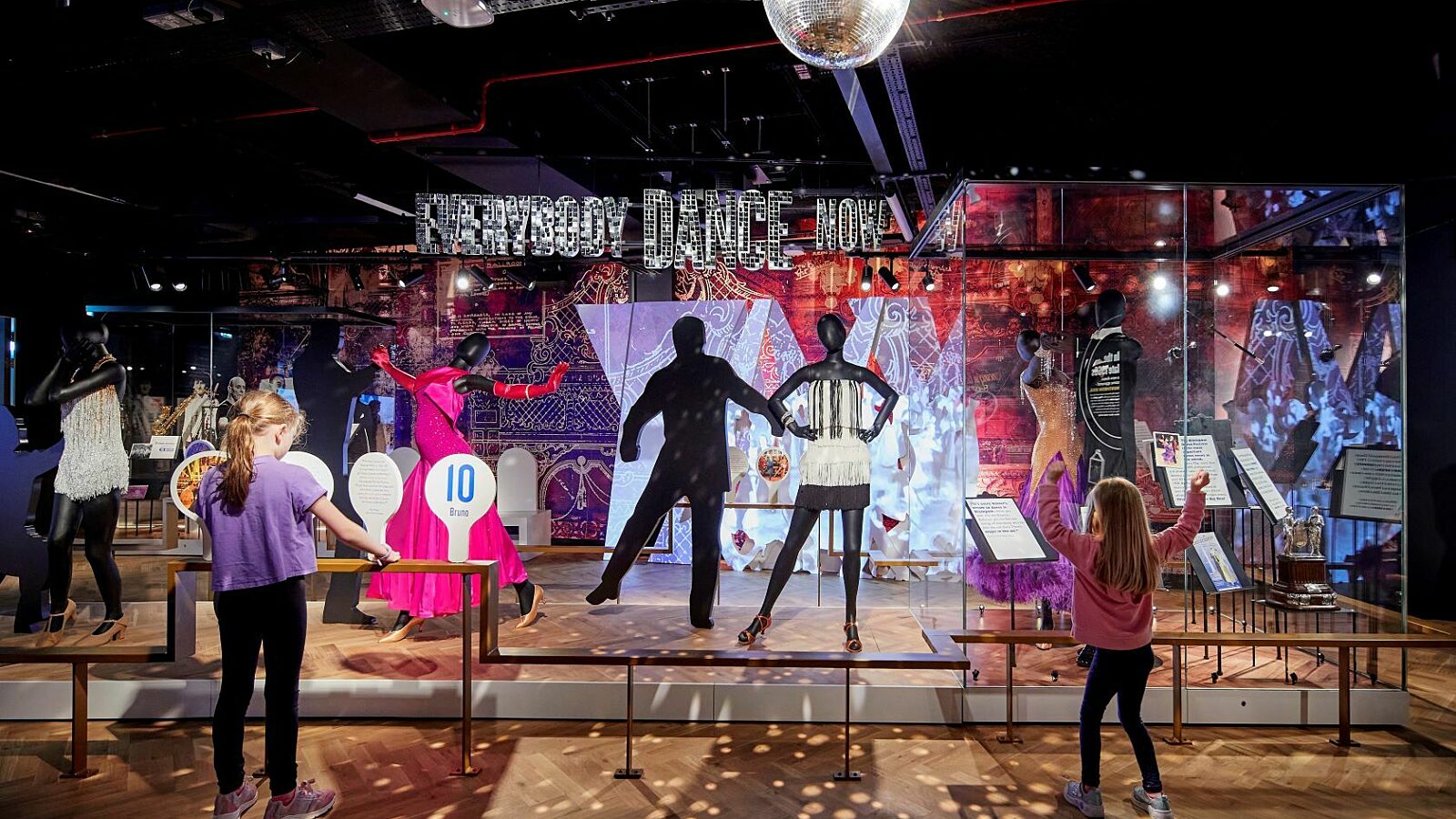 Dance gallery at Showtown.  Two girls dancing and playing with score paddles with dance costumes on models