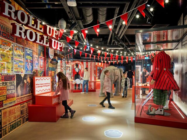 Image of Roll up gallery with family exploring circus related objects including clown and ring master costumes.