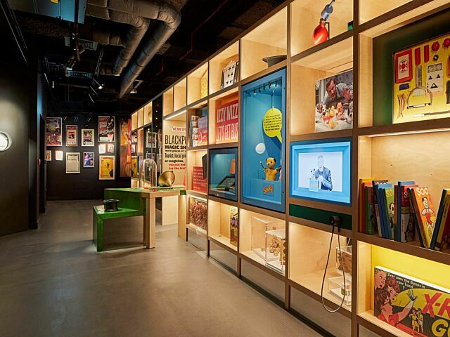 Images shows inside the How's Tricks gallery. Book cases with objects related to magic and joke shops